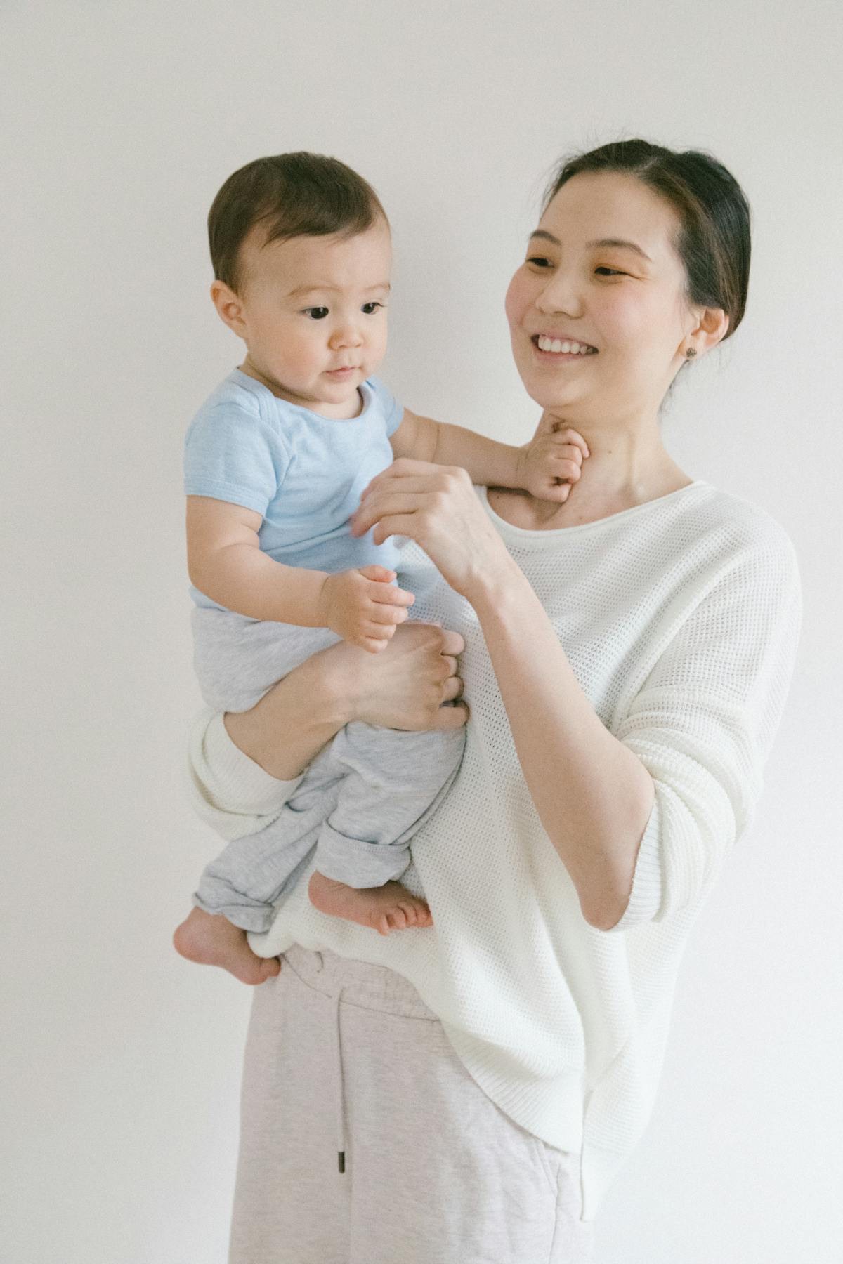 A caregiver gently holding a baby at home