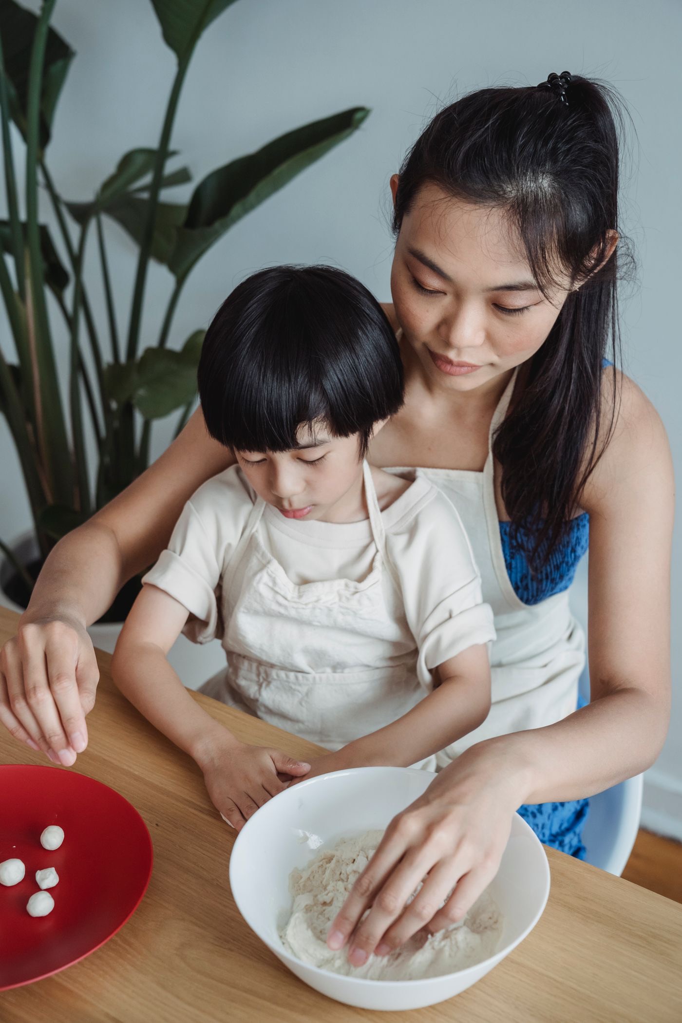 An EZHelper domestic helper preparing a meal with a child at home